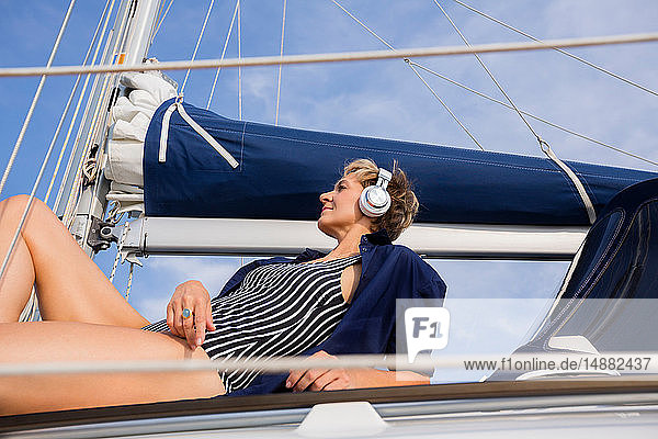 Reife Frau beim Sonnenbaden auf einem Segelboot auf dem Chiemsee  Bayern  Deutschland