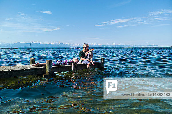 Geschwister entspannen am Pier  Starnberger See  Bayern  Deutschland