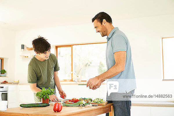 Junge und sein Vater bereiten das Essen an der Küchentheke