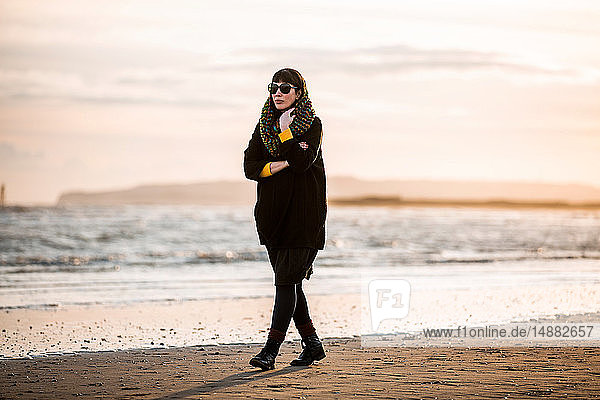Frau geht allein am Strand spazieren