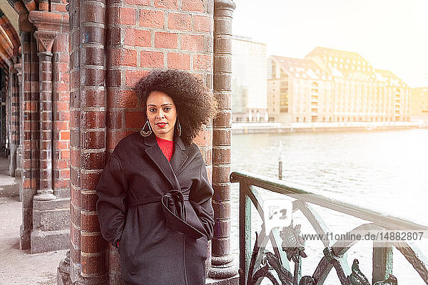Mittlere erwachsene Frau in stilvollem Mantel auf der Oberbaumbrücke  Porträt  Berlin  Deutschland