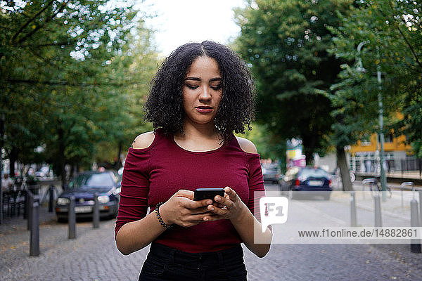 Junge Frau mit Mobiltelefon  Berlin  Deutschland