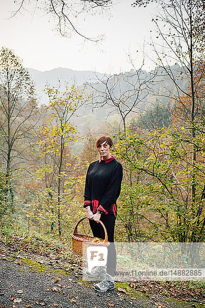 Woman with basket on hillside road  Rezzago  Lombardy  Italy