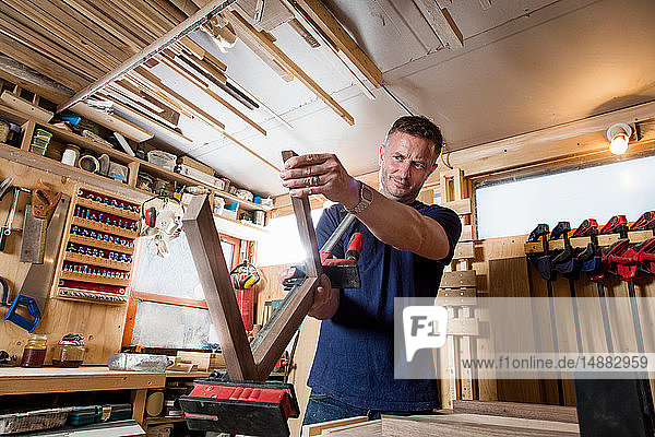 Handwerker  der Teile für einen Holzgegenstand vorbereitet