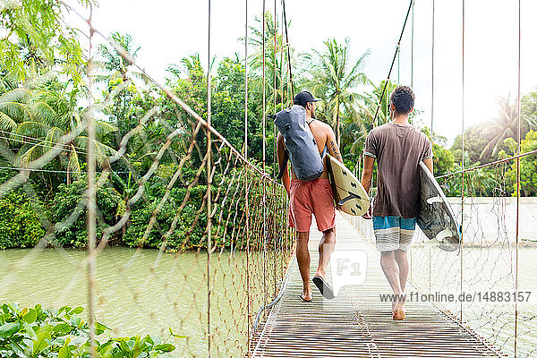 Men with surfboards on rope bridge  Pagudpud  Ilocos Norte  Philippines