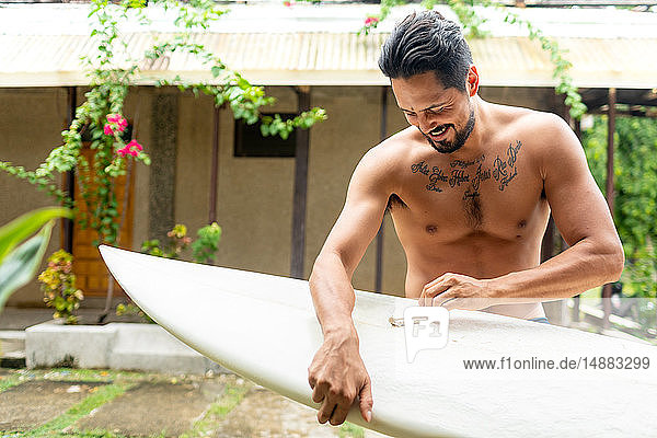 Mann bereitet Surfbrett vor  Pagudpud  Ilocos Norte  Philippinen
