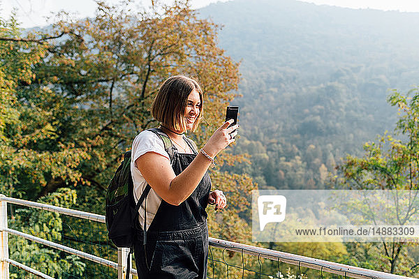 Woman taking photo on hillside  Rezzago  Lombardy  Italy