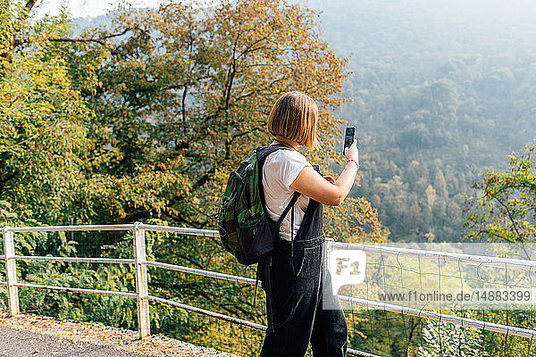 Woman taking photo on hillside  Rezzago  Lombardy  Italy