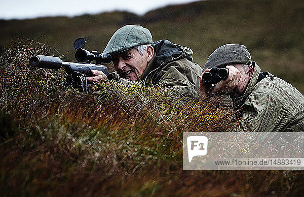 Mensch und Wildhüter bei der Pirsch auf Moorland  Schottische Highlands