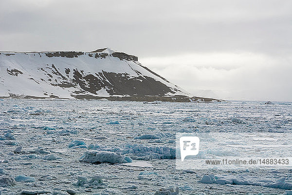 Gefrorene Landschaft und entfernter schneebedeckter Berg  Wahlenberg Fjord  Nordaustlandet  Svalbard  Norwegen