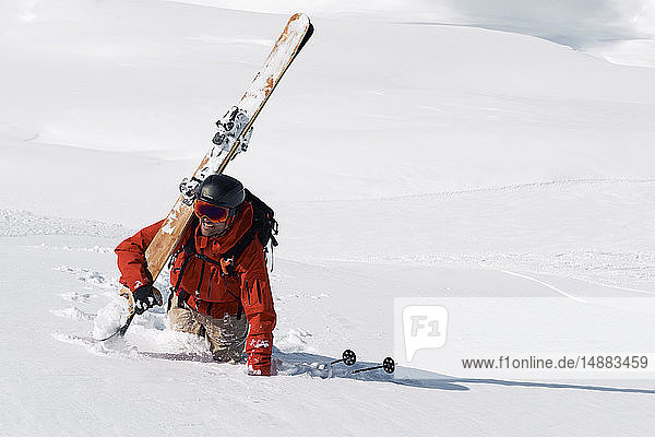 Männlicher Skifahrer stapft durch Tiefschnee den Berg hinauf  Alpe-d'Huez  Rhône-Alpes  Frankreich