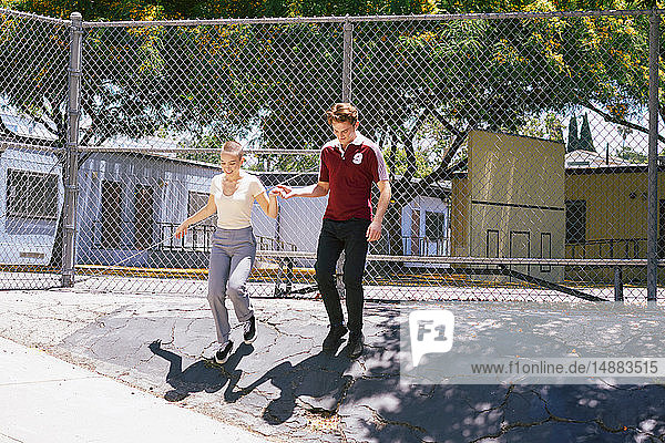 Junger Mann gibt einer Freundin im Park eine helfende Hand  Los Angeles  Kalifornien  USA