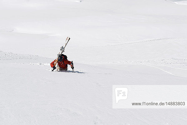 Männlicher Skifahrer stapft durch Tiefschnee den Berg hinauf  Alpe-d'Huez  Rhône-Alpes  Frankreich