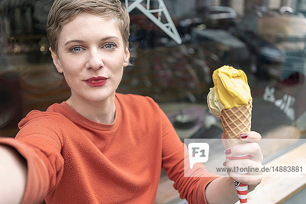Frau  die sich mit Eiscreme vor dem Laden selbstständig macht