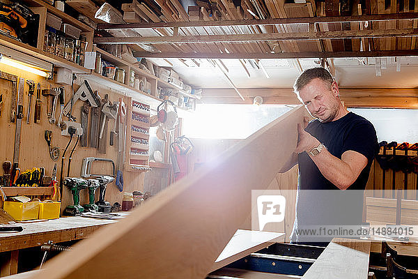 Craftsman preparing planks of wood in workshop
