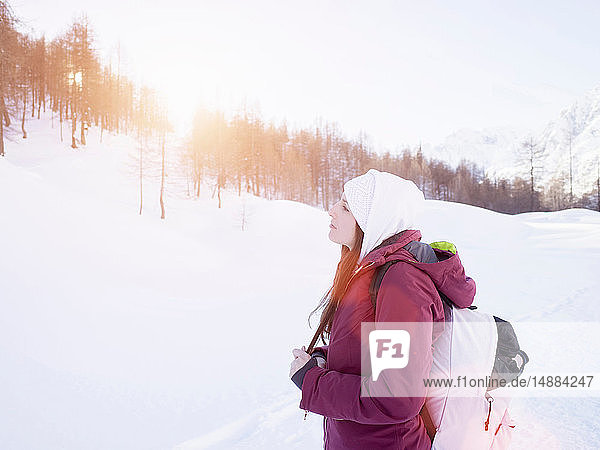 Young woman in knit hat looking out at snow covered landscape  Alpe Ciamporino  Piemonte  Italy