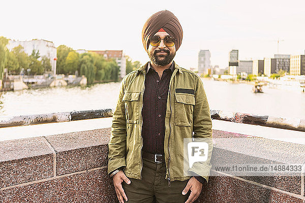 Indischer Mann erkundet Stadt  Fluss im Hintergrund  Berlin  Deutschland