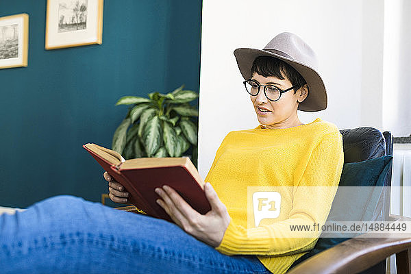 Frau entspannt sich im Liegestuhl und liest ein Buch
