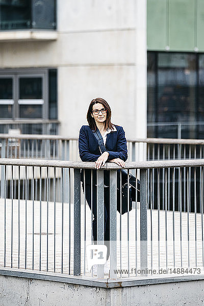 Porträt einer selbstbewussten Geschäftsfrau  die vor einem Bürogebäude in der Stadt steht