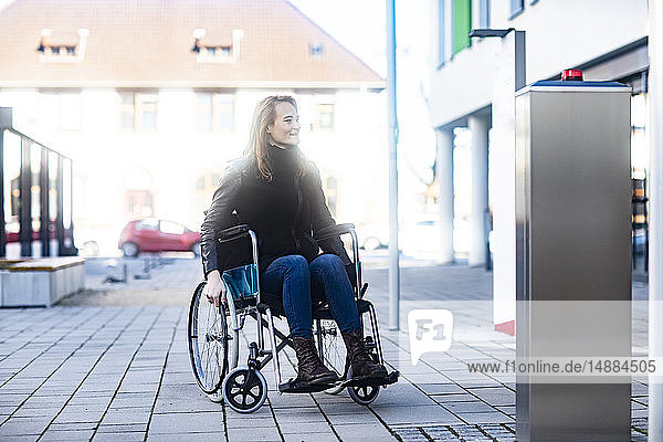 Junge Frau im Rollstuhl in der Stadt