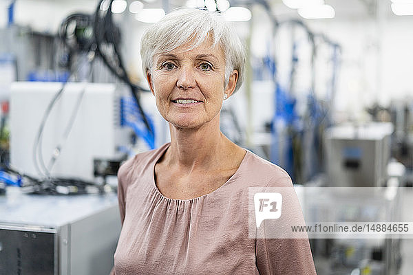 Porträt einer selbstbewussten älteren Frau in einer Fabrik