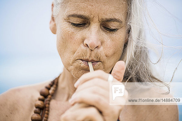 Porträt einer älteren Hippie-Frau  die im Freien raucht