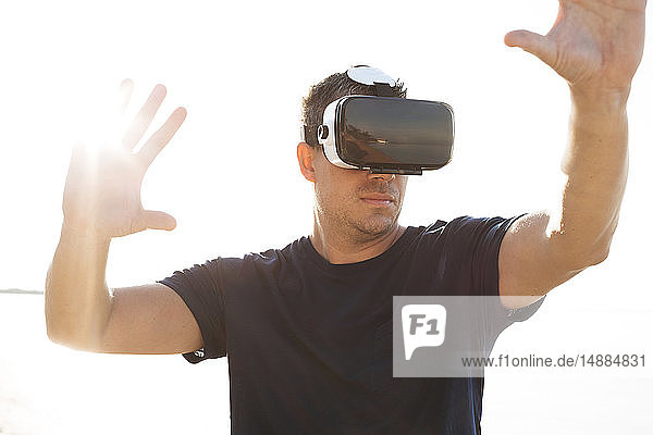 Mann mit VR-Brille am Strand