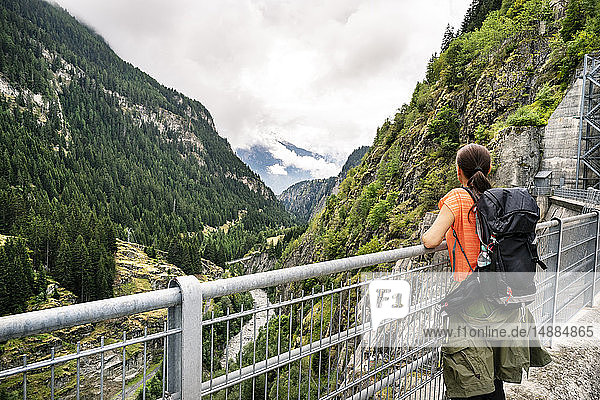 Schweiz  Wallis  Frau auf einer Wanderung von Blatten nach Riederalm auf einer Staumauer