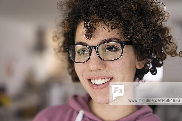 Portrait of a young woman with curly hair  wearing glasses