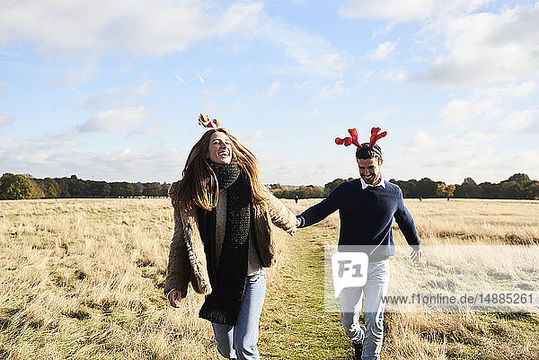 Glückliches  sorgenfreies Paar mit weihnachtlichem Kopfschmuck auf dem Land