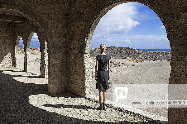 Spanien, Teneriffa, Abades, Sanatorio de Abona, Frau am Bogenfenster im Geisterstadtgebäude stehend