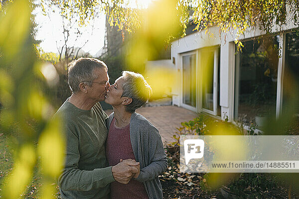 Zärtliches Seniorenpaar küsst sich im Garten