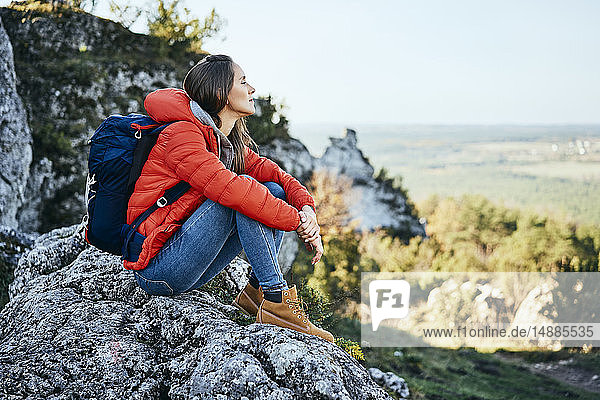 Woman on a hiking trip in the mountains resting on a rock