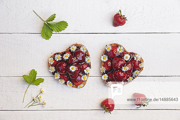 Hausgemachte Erdbeer-Herztörtchen mit Gänseblümchen  essbare Blumen