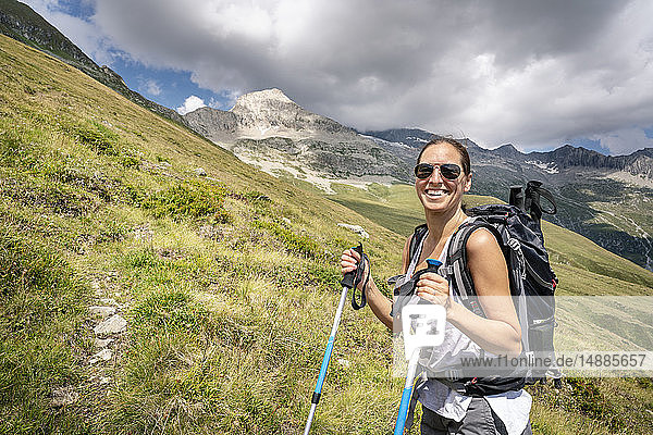 Schweiz  Wallis  Porträt einer glücklichen Frau auf einer Wanderung in den Bergen Richtung Foggenhorn