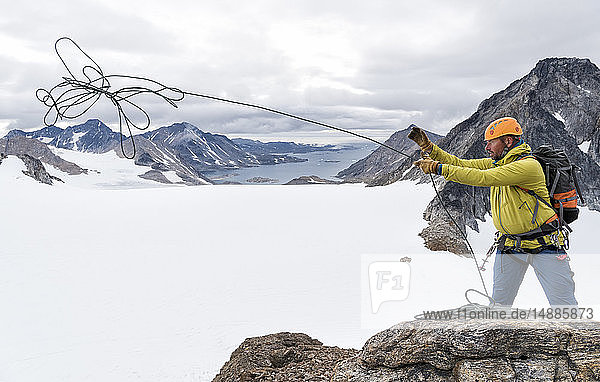 Greenland  Sermersooq  Kulusuk  Schweizerland Alps  mountaineer on summit throwing rope