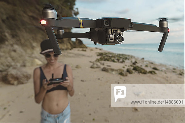 Indonesien  Bali  Nusa Dua  Frau fliegende Drohne am Strand