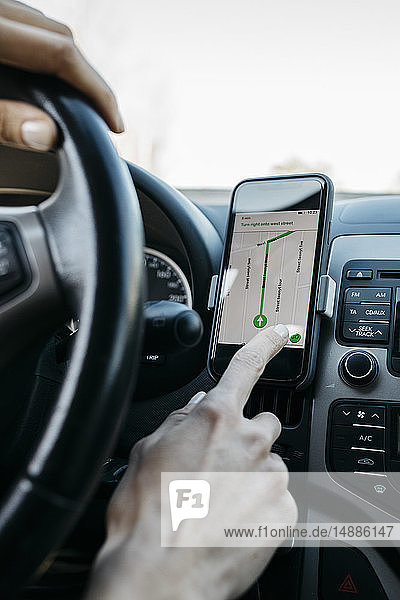 Close-up of woman driving in a car using a telephone navigation app