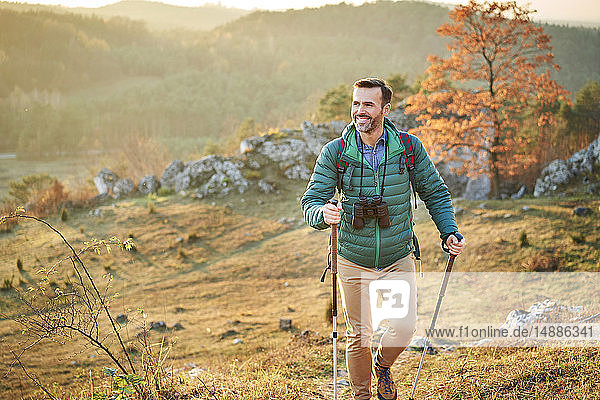Happy man walking on trail on a hiking trip in the mountains