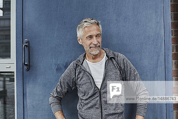 Portrait of mature man wearing tracksuit top in front of gym