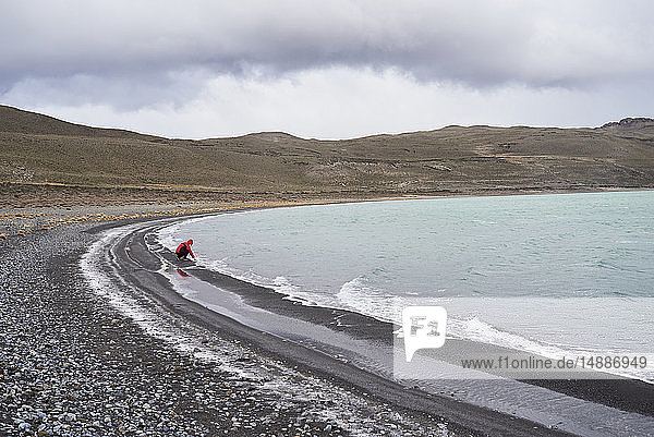 Chile  Patagonien  Mann berührt kaltes Wasser im Torres del Paine Nationalpark