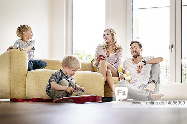 Glückliche Familie  die in ihr neues Zuhause einzieht  Eltern  die mit ihren Kindern spielen