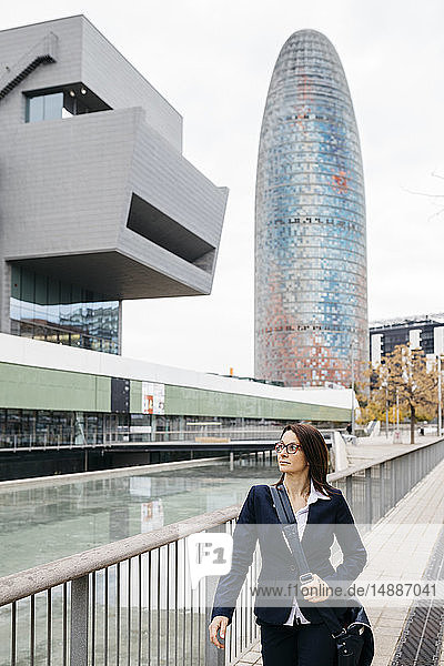 Spanien  Barcelona  Geschäftsfrau geht vor einem Bürogebäude in der Stadt