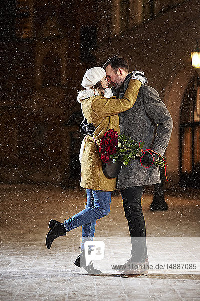 Couple in love hugging in the city in winter