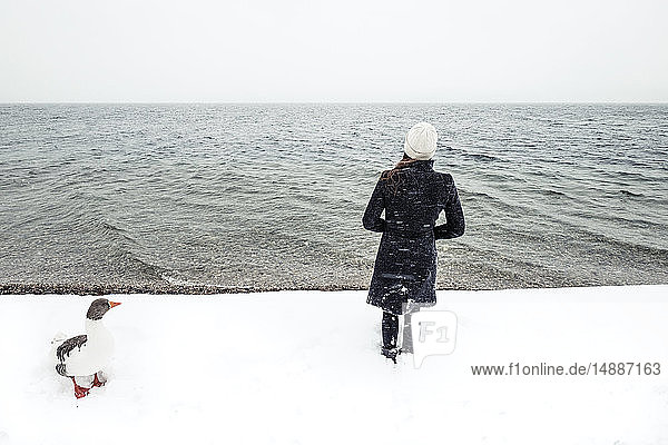 Graugans und junge Frau im Winter am Starnberger See
