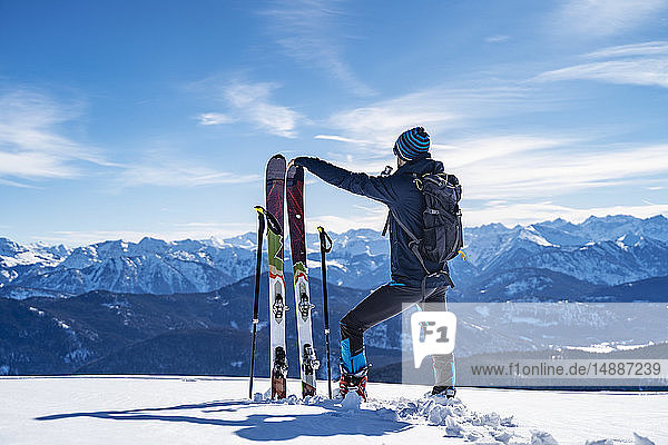 Deutschland  Bayern  Brauneck  Mann auf Skitour im Winter in den Bergen bei einer Pause