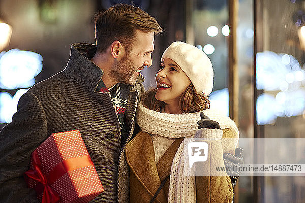 Glückliches Paar auf Einkaufstour zur Weihnachtszeit beim gegenseitigen Anschauen