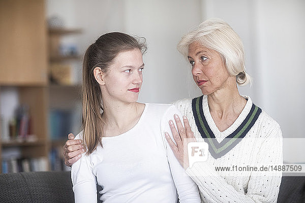Sceptical young woman looking at her mother begging