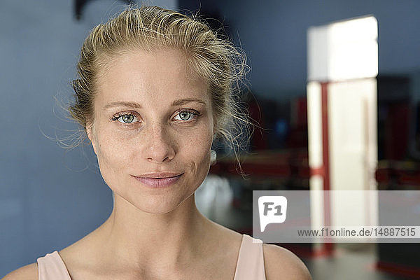 Porträt einer selbstbewussten jungen blonden Frau in einer Turnhalle