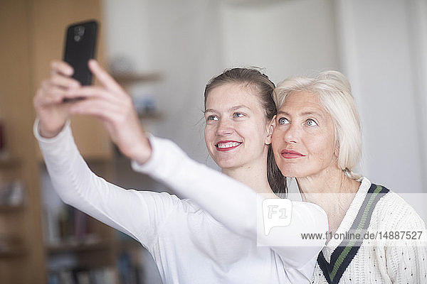 Porträt einer lächelnden jungen Frau  die sich selbst mit ihrer Mutter vergnügt